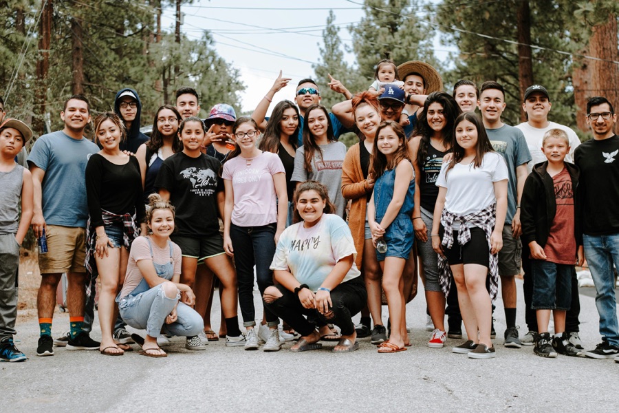 Large smiling group of friends and family posing together outdoors
